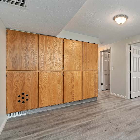 an empty living room with wooden cabinets and a white door