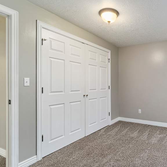 a room with a white door and carpeted floor.