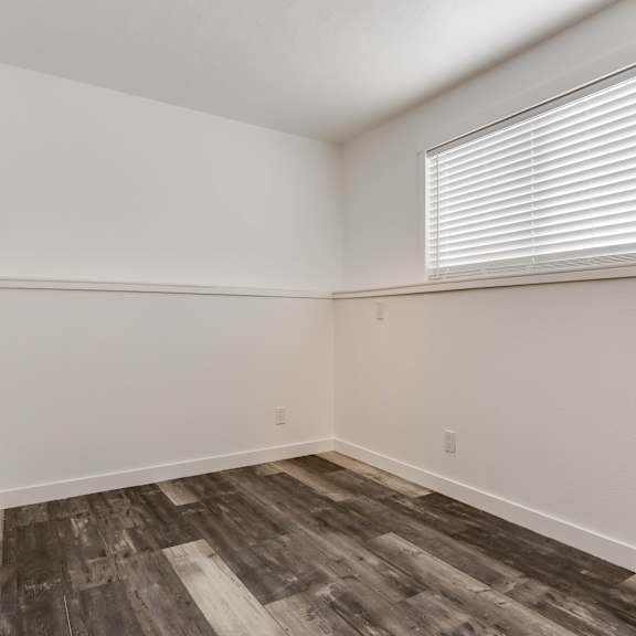 a room with a window and wooden flooring.