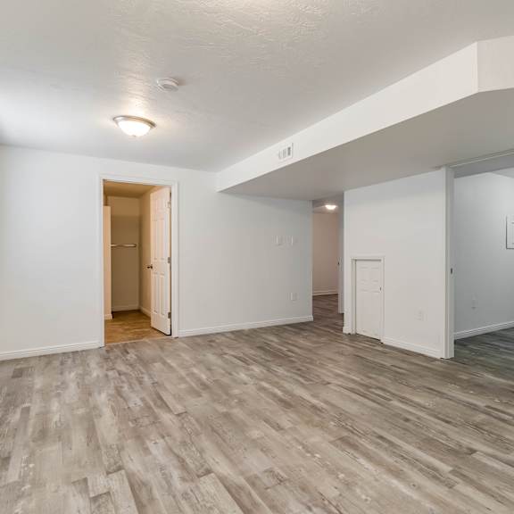 an empty living room with white walls and wood flooring