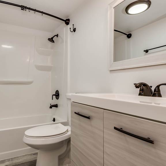 a white bathroom with a toilet, sink, and bathtub.