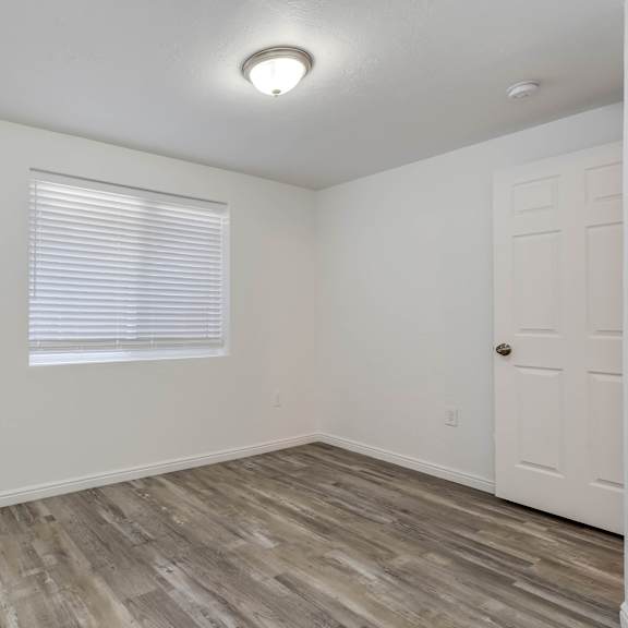 the living room of our studio apartment atrium with white walls and wood flooring