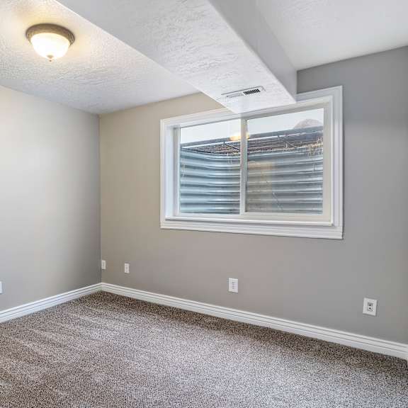 a room with a window and carpeted floor.