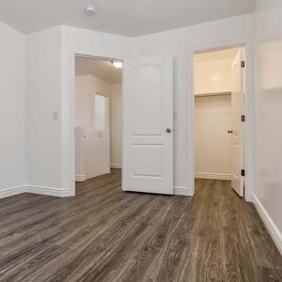 an empty living room with white walls and wood flooring