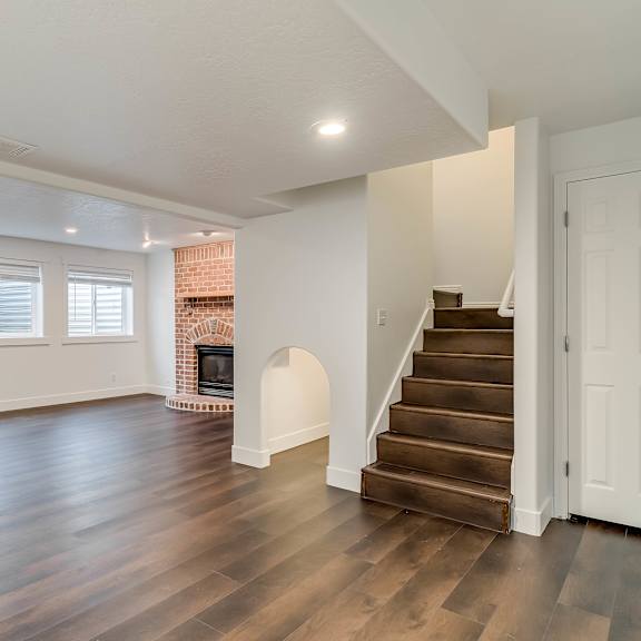 a room with wooden floors and a staircase leading to another room.