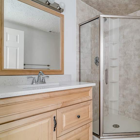 a bathroom with a toilet, sink, and shower.