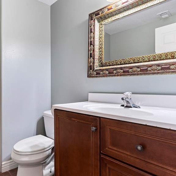 a white toilet sits next to a white sink in a bathroom.