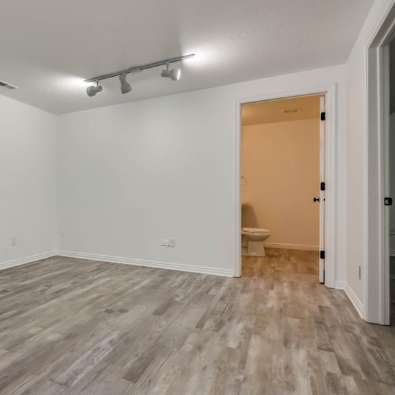 a room with a wooden floor and a door on the right side.