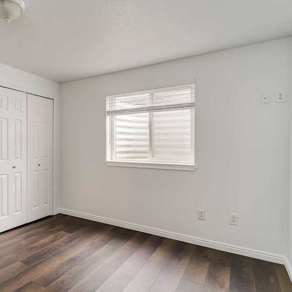 a room with a white door and a window with blinds.