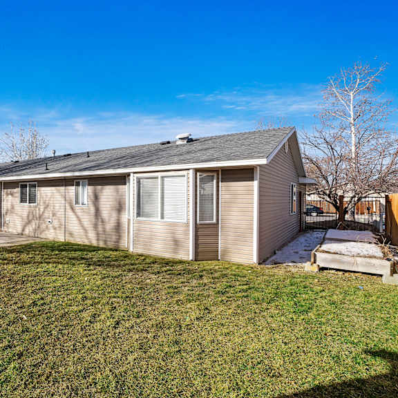 the back of a house with a yard and a fence