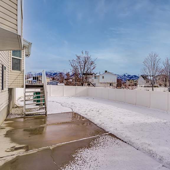 a snowy landscape with a building and a shed.