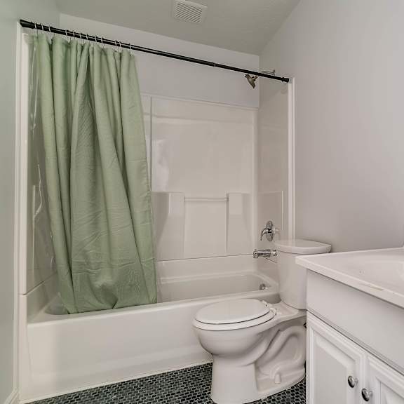 a white bathroom with a toilet, sink, and bathtub.