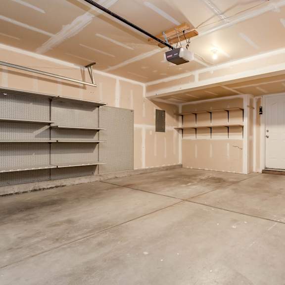 the interior of a garage with white walls and a concrete floor