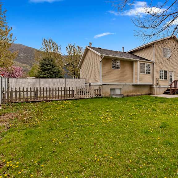 a house with a yard and a fence in front of it