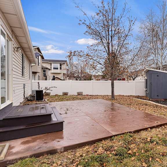 a backyard with a concrete patio and a shed.