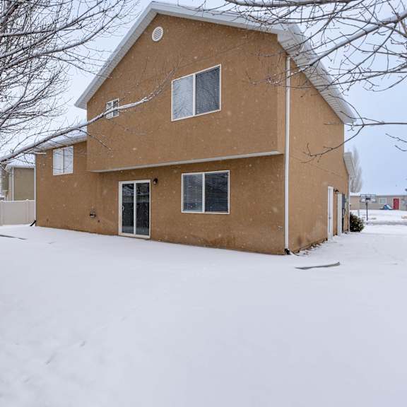 a house with a brown roof and a tree in front of it.