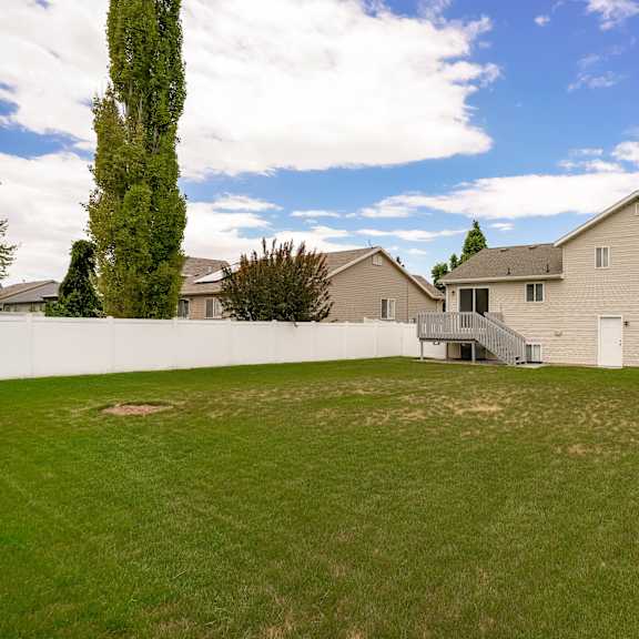 a large house with a white fence and a green lawn.