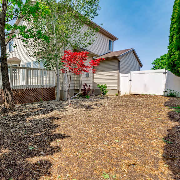 a house with a yard with trees and a fence