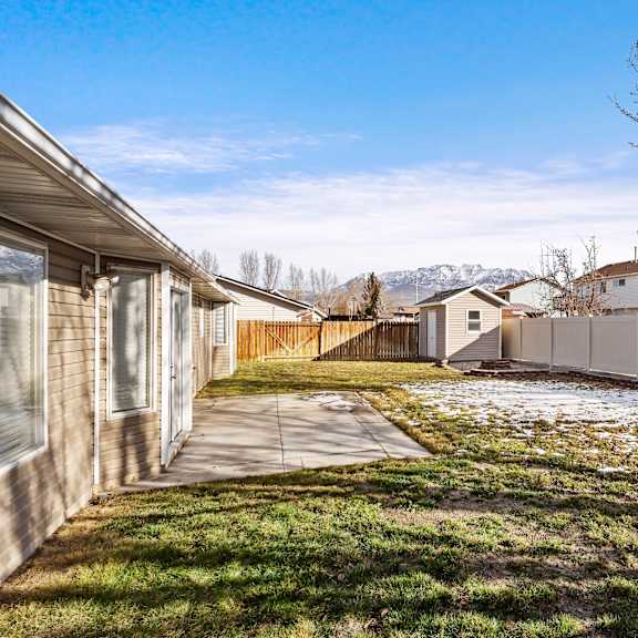 the backyard of a house with a yard and a chain link fence and a house