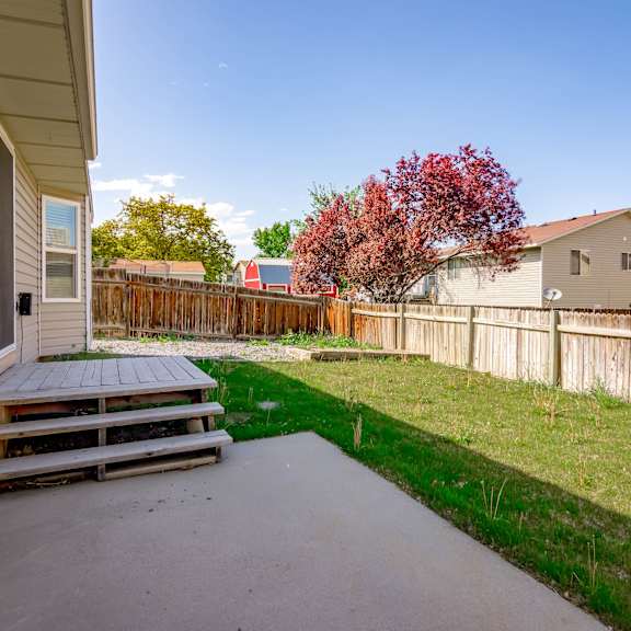a backyard with a deck and a fence.