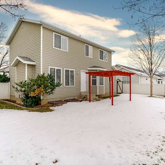 a house with a red awning and a white fence.