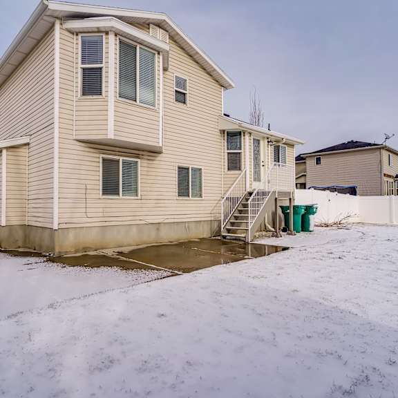 a house with a snow-covered ground in front of it.