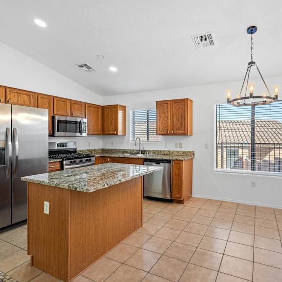 a kitchen with stainless steel appliances and a marble counter top