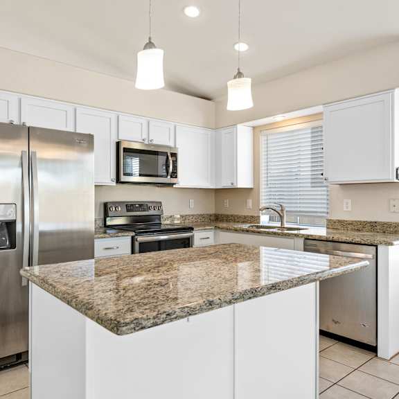 a kitchen with granite countertops and stainless steel appliances.