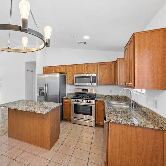 a kitchen with wooden cabinets and granite counter tops