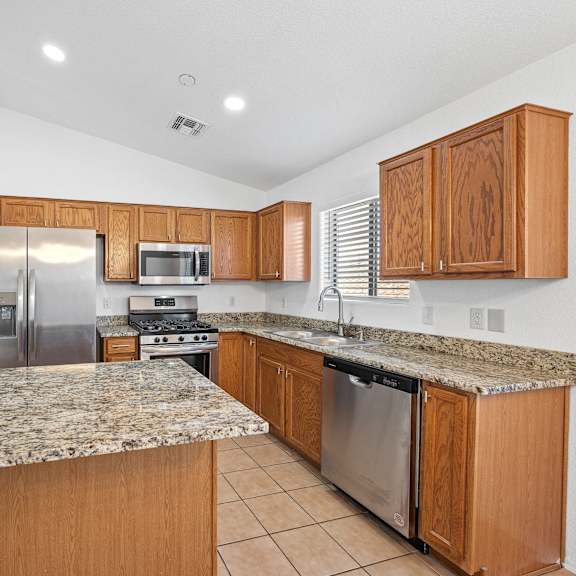 the kitchen has granite counter tops and stainless steel appliances