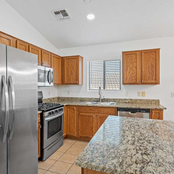 the kitchen has granite counter tops and stainless steel appliances