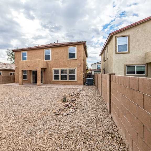 a house with a gravel driveway in front.