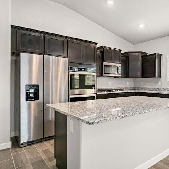 a modern kitchen with a granite countertop and stainless steel appliances.