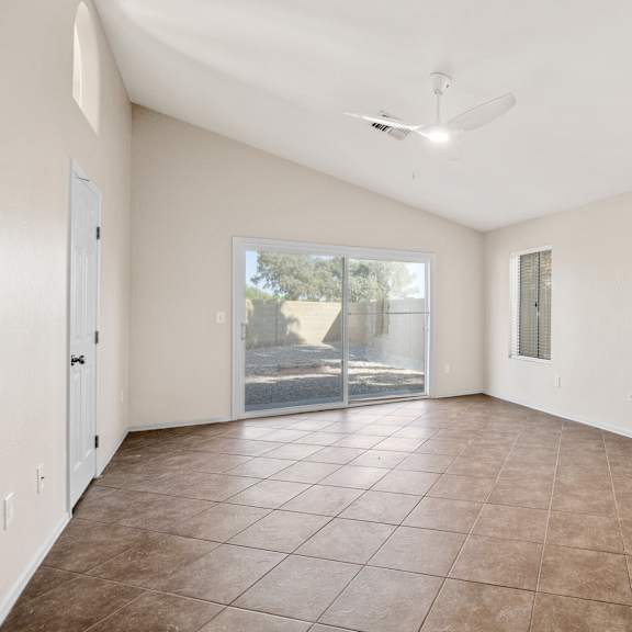 a spacious room with a sliding glass door leading to a patio.