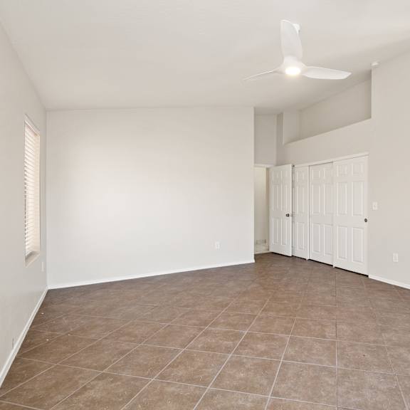 empty room with white walls and a ceiling fan.