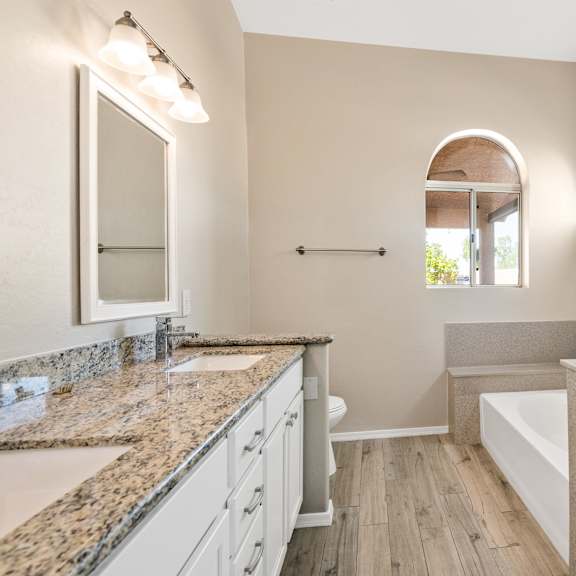 a bathroom with a granite countertop and a walk-in shower.