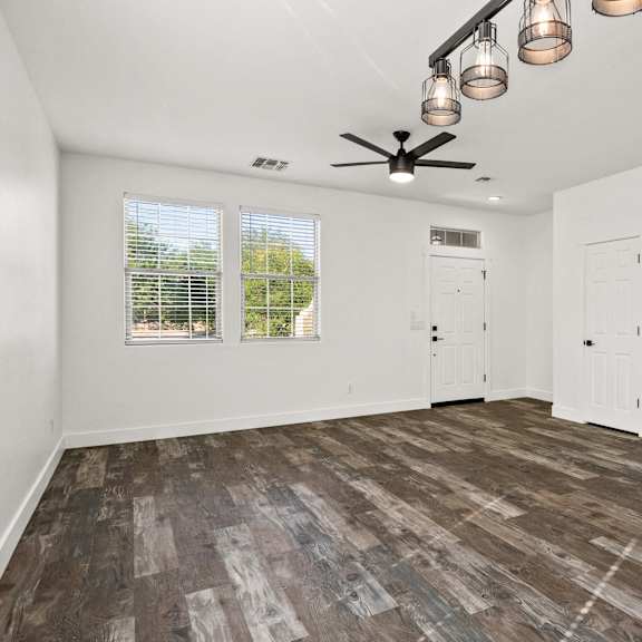 a room with a ceiling fan and a window with blinds.