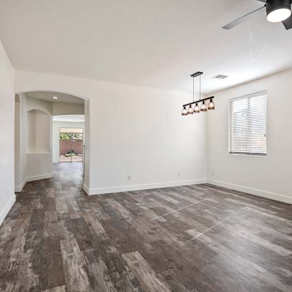 a room with a wood floor and a ceiling fan.