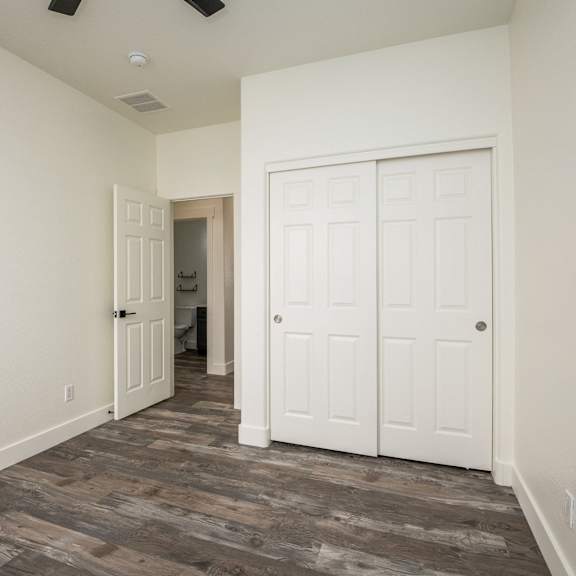 a room with a wooden floor and two white doors.