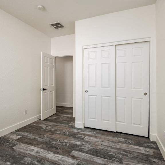 a room with a white door and a grey floor.