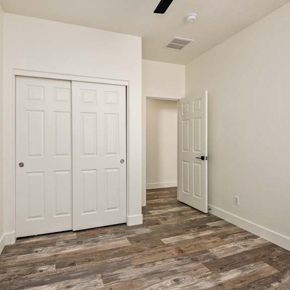 a room with a white door and a wooden floor.