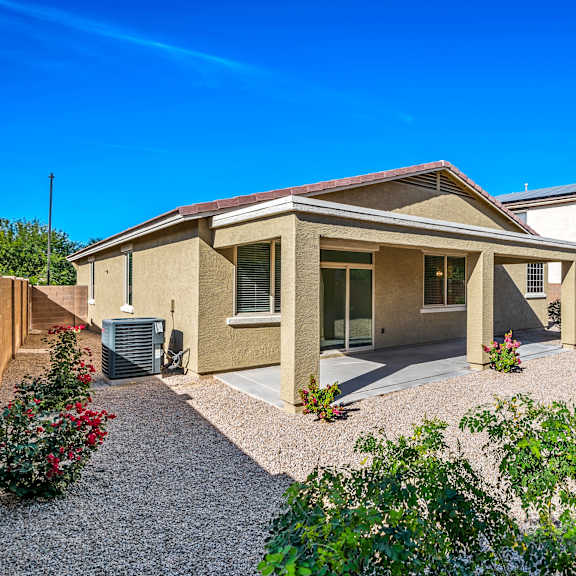 a house with a gravel driveway and landscaping in front.