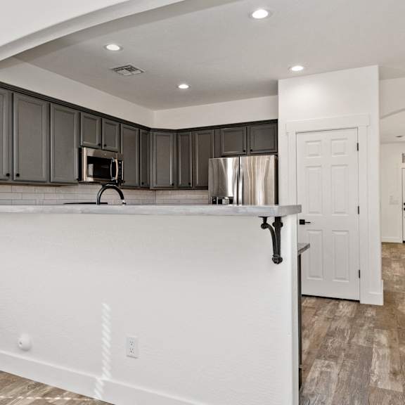 a kitchen with a white counter and black cabinets.