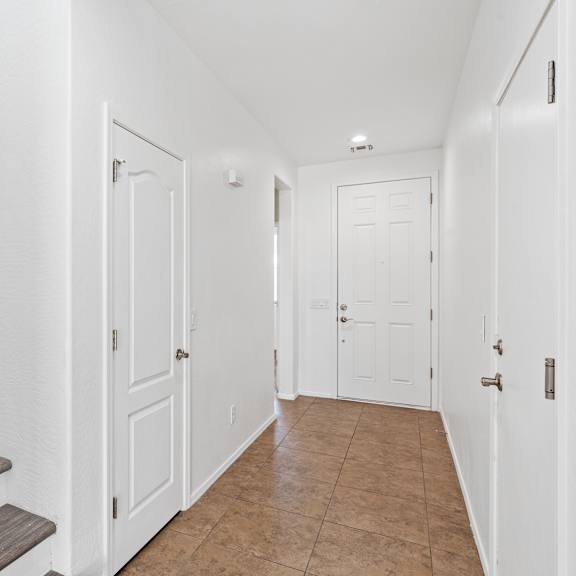 a hallway with white doors and a staircase with wooden steps.