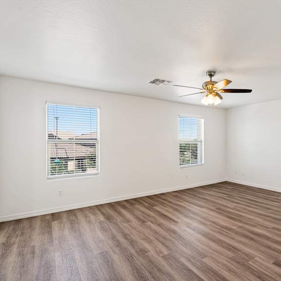 empty room with wooden floor and ceiling fan.