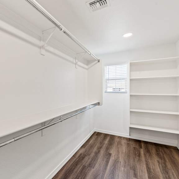 a white wall with a window and shelves.