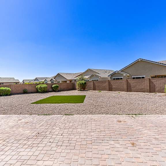 a row of houses with a gravel driveway in the foreground.