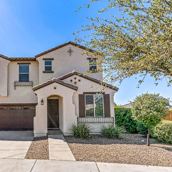 a two-story house with a garage and a driveway.