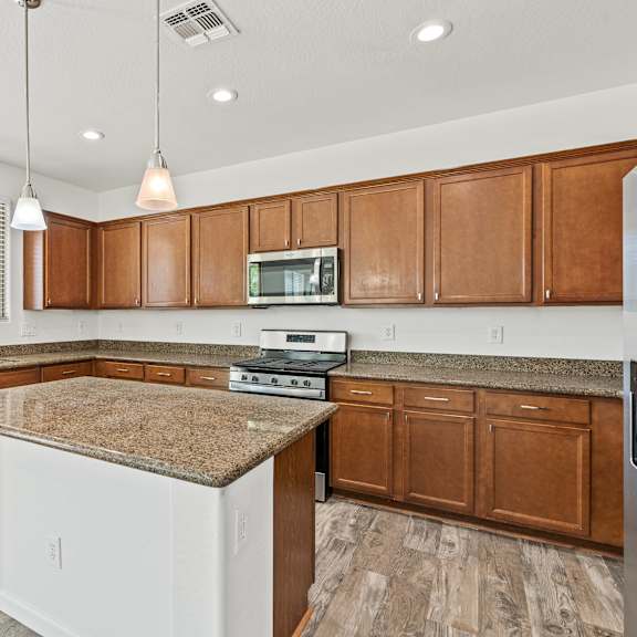 a kitchen with brown cabinets and a granite countertop.