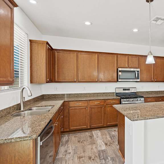 a kitchen with wooden cabinets and a granite countertop.